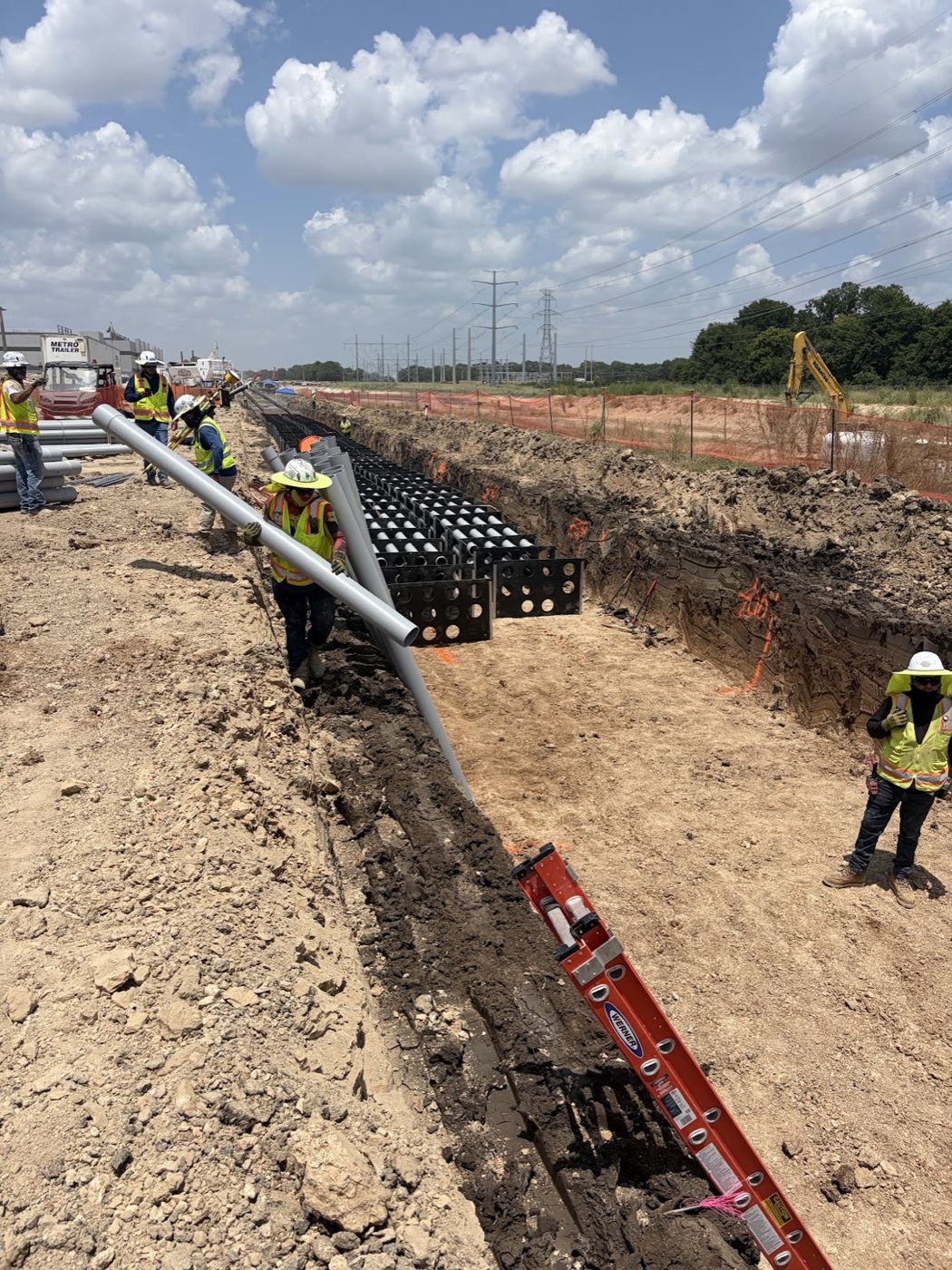 Cornerstone crew setting conduit spacers in a duct bank under transmission lines